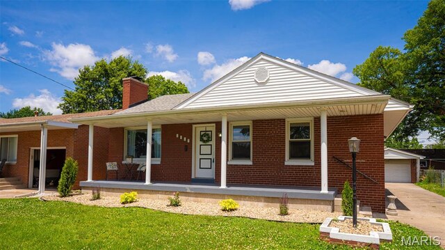 2917 Grand Ave, Granite City, IL 62040 - view of front of house featuring a porch, a chimney, brick siding, a front yard, and an outdoor structure