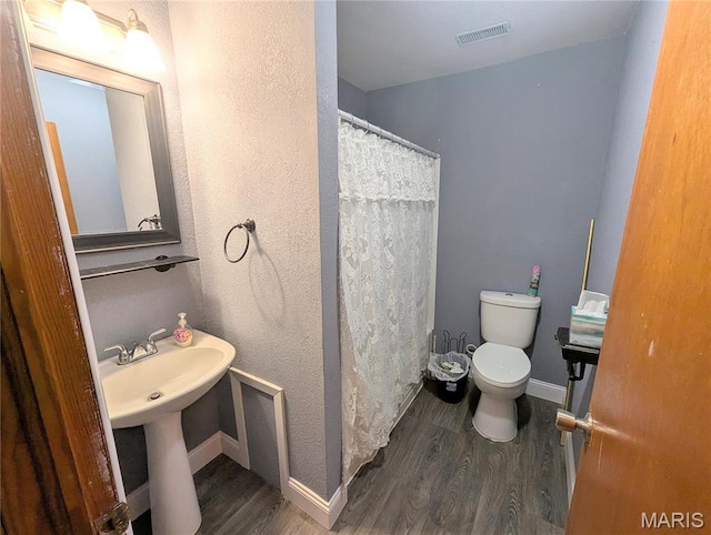 303 N Main St, Campbell, MO 63933 - bathroom with toilet, wood finished floors, baseboards, and a shower with shower curtain
