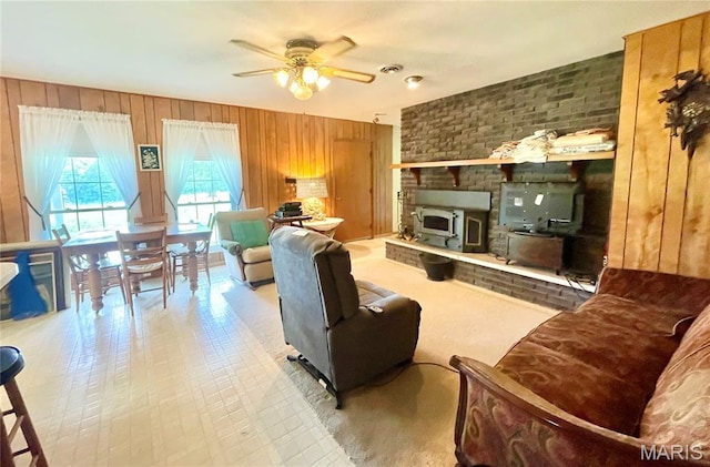 5815 Robin Ln, Troy, MO 63379 - living room featuring wooden walls, ceiling fan, and a wood stove