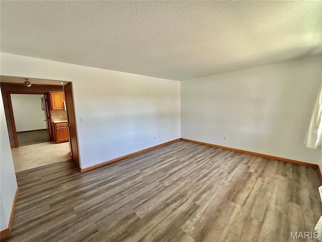 1101 S Mildred Blvd, Salem, MO 65560 - spare room with dark wood-style flooring, baseboards, and a textured ceiling