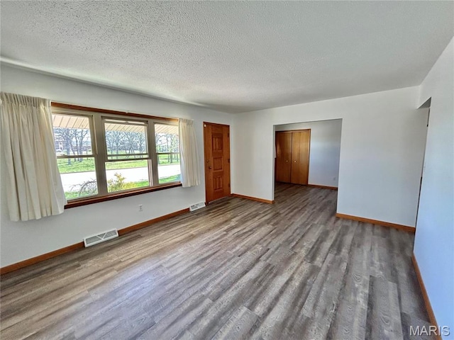 1101 S Mildred Blvd, Salem, MO 65560 - empty room featuring wood finished floors, baseboards, and a textured ceiling