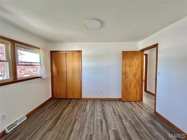 1101 S Mildred Blvd, Salem, MO 65560 - unfurnished bedroom featuring wood finished floors, a textured ceiling, baseboards, and a closet