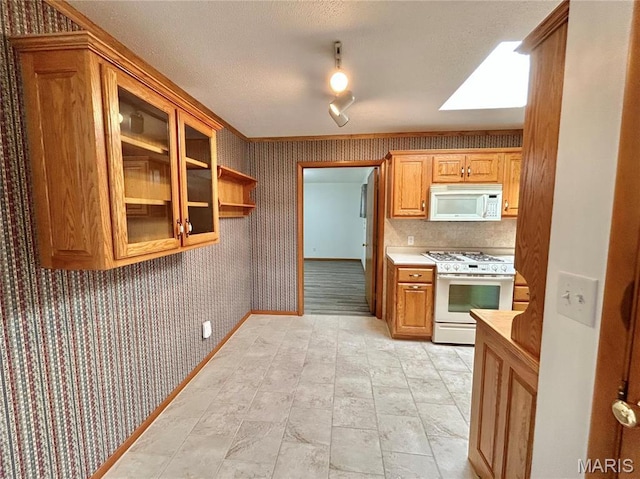 1101 S Mildred Blvd, Salem, MO 65560 - kitchen with white appliances, wallpapered walls, light countertops, a textured ceiling, and a skylight