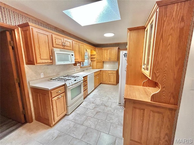 1101 S Mildred Blvd, Salem, MO 65560 - kitchen with white appliances, a skylight, stone tile flooring, decorative backsplash, and light countertops