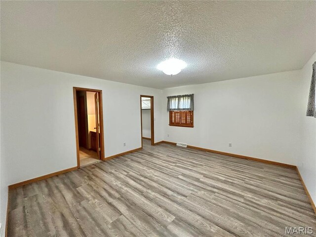 1101 S Mildred Blvd, Salem, MO 65560 - empty room with wood finished floors, a textured ceiling, and baseboards
