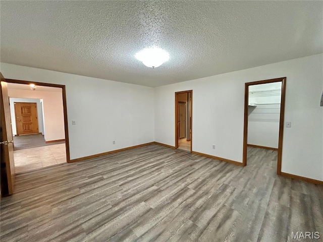 1101 S Mildred Blvd, Salem, MO 65560 - unfurnished room featuring wood finished floors, a textured ceiling, and baseboards