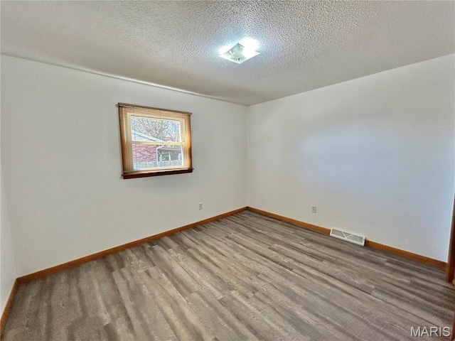 1101 S Mildred Blvd, Salem, MO 65560 - unfurnished room featuring baseboards, a textured ceiling, and wood finished floors