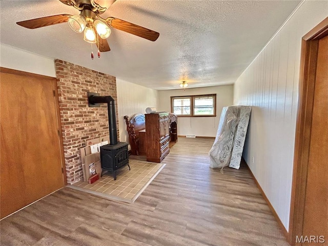 1101 S Mildred Blvd, Salem, MO 65560 - bedroom featuring a wood stove, wood finished floors, and a textured ceiling