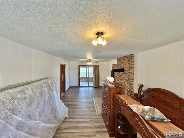 1101 S Mildred Blvd, Salem, MO 65560 - dining room with light wood-style flooring, a textured ceiling, a wood stove, and a ceiling fan