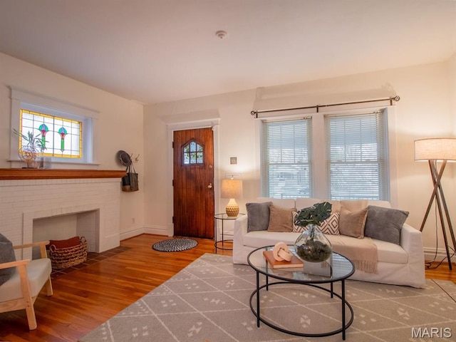 living area featuring wood finished floors, baseboards, and a fireplace