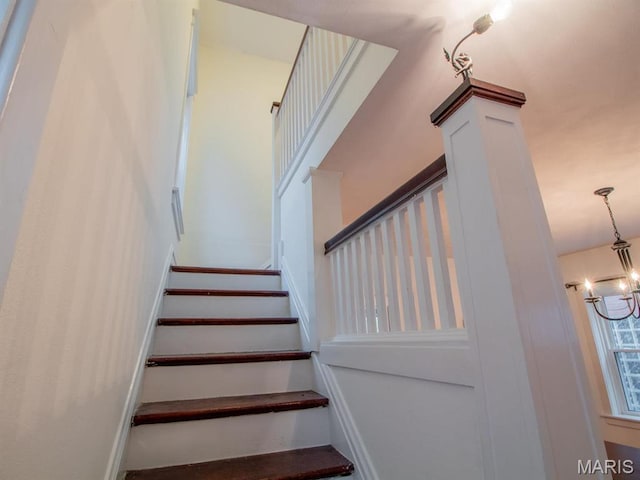 stairway featuring a chandelier