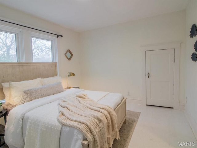 bedroom featuring light floors and baseboards