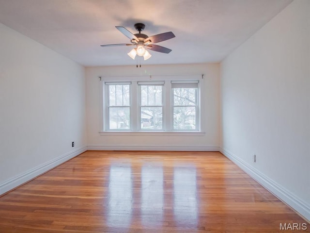 spare room with light wood-style floors, a ceiling fan, and baseboards