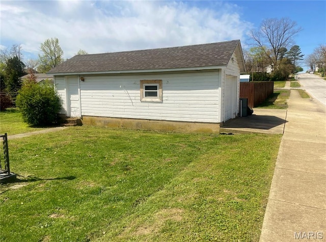 109 N Oak St, Rolla, MO 65401 - view of side of home featuring a yard, a shingled roof, and an outdoor structure