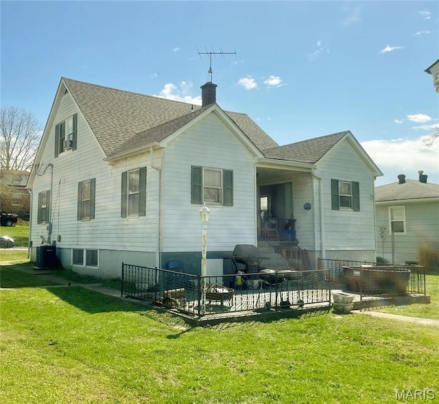 109 N Oak St, Rolla, MO 65401 - back of house featuring a lawn, central AC, a chimney, and roof with shingles