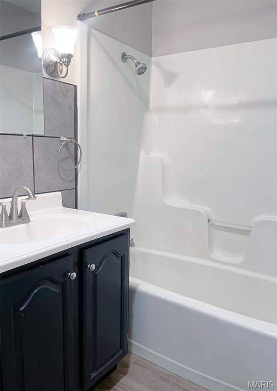 109 N Oak St, Rolla, MO 65401 - bathroom featuring wood finished floors, vanity, and shower / bath combination