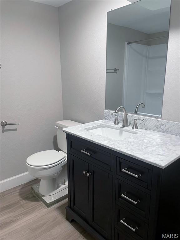 109 N Oak St, Rolla, MO 65401 - bathroom featuring vanity, wood finished floors, toilet, and baseboards
