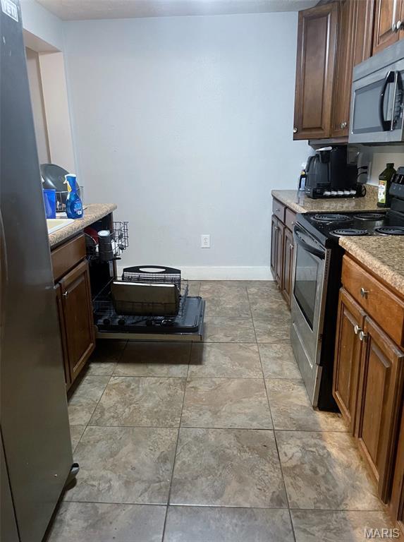709 E 10th St, Rolla, MO 65401 - kitchen with stainless steel appliances, light countertops, and baseboards