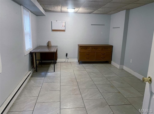 709 E 10th St, Rolla, MO 65401 - below grade area with a baseboard radiator, a drop ceiling, and baseboards