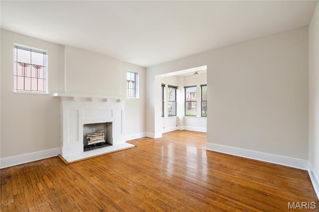 6026 Waterman Blvd Unit 1W, Saint Louis, MO 63112 - unfurnished living room featuring a fireplace, wood finished floors, and baseboards