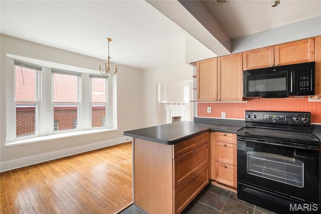 6026 Waterman Blvd Unit 1W, Saint Louis, MO 63112 - kitchen with black appliances, a peninsula, baseboards, and dark countertops