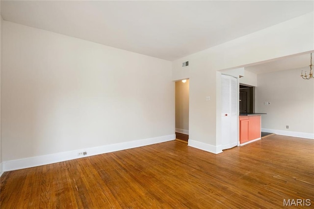6026 Waterman Blvd Unit 1W, Saint Louis, MO 63112 - empty room with a chandelier, wood finished floors, and baseboards
