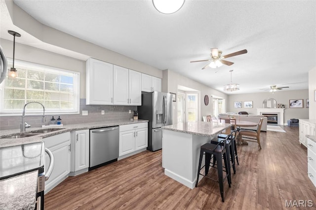 11 Country Crossing Estates Dr, Saint Peters, MO 63376 - kitchen with appliances with stainless steel finishes, ceiling fan, wood finished floors, white cabinetry, and a textured ceiling