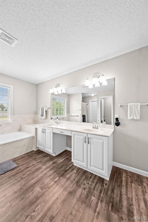 11 Country Crossing Estates Dr, Saint Peters, MO 63376 - full bathroom with wood finished floors, a bath, double vanity, a textured ceiling, and a chandelier