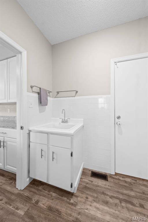 11 Country Crossing Estates Dr, Saint Peters, MO 63376 - washroom featuring a wainscoted wall, dark wood-style floors, a textured ceiling, and tile walls