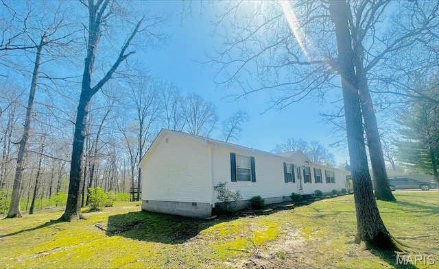 view of property exterior featuring a lawn and crawl space