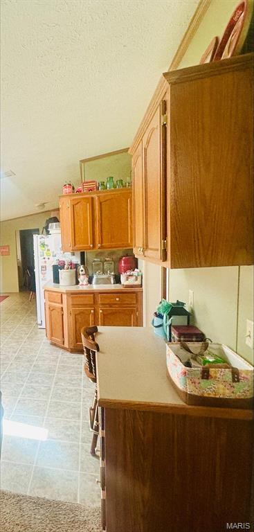kitchen with light countertops, brown cabinets, a peninsula, and light flooring