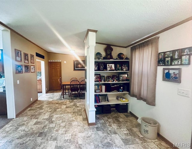 hall with crown molding, stone finish floors, decorative columns, and baseboards