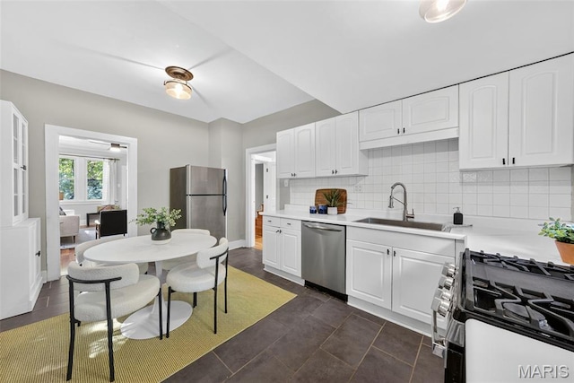 837 Tuxedo Blvd, Saint Louis, MO 63119 - kitchen with appliances with stainless steel finishes, white cabinetry, backsplash, light countertops, and dark tile patterned flooring