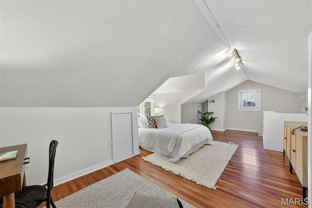 837 Tuxedo Blvd, Saint Louis, MO 63119 - bedroom featuring a textured ceiling, vaulted ceiling, multiple windows, and wood finished floors