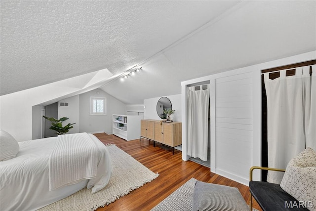 837 Tuxedo Blvd, Saint Louis, MO 63119 - bedroom featuring vaulted ceiling, wood finished floors, and a textured ceiling