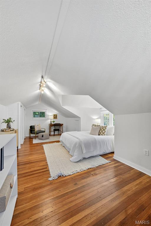 837 Tuxedo Blvd, Saint Louis, MO 63119 - bedroom with lofted ceiling, hardwood / wood-style floors, and a textured ceiling