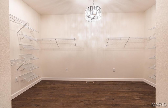 235 Sunny Dr, Rolla, MO 65401 - walk in closet with dark wood finished floors and a chandelier