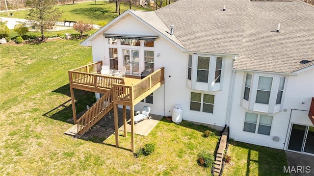 rear view of property featuring french doors, stairs, a wooden deck, roof with shingles, and a lawn