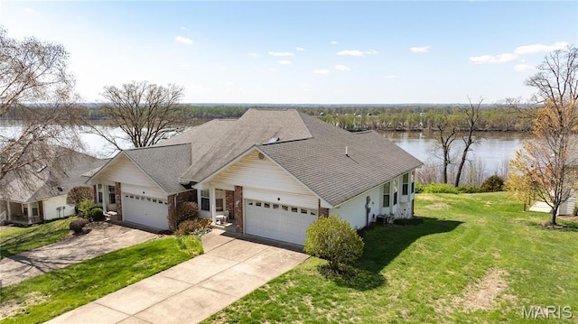 view of front of home with a garage, a water view, a front yard, driveway, and a shingled roof