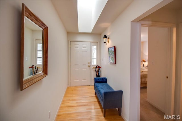 hall featuring light wood finished floors and baseboards