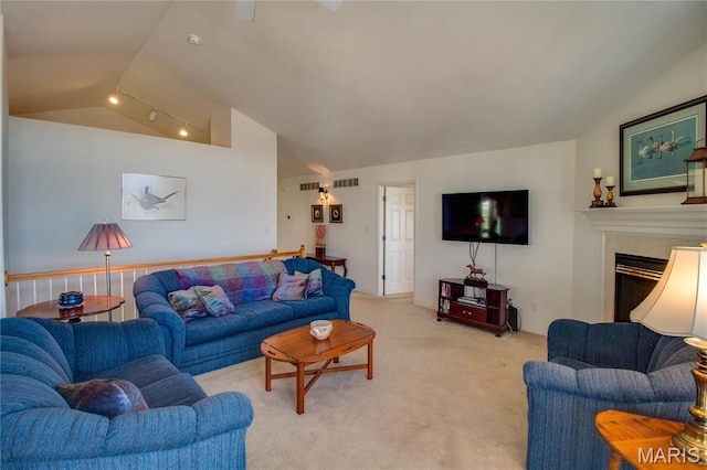 living area featuring vaulted ceiling, light colored carpet, and a fireplace