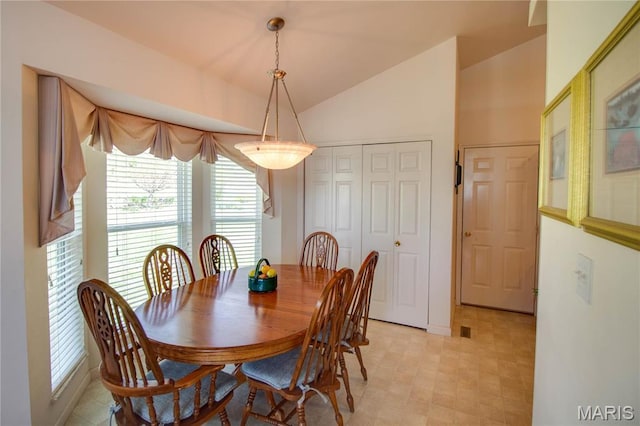 dining room featuring lofted ceiling and light floors