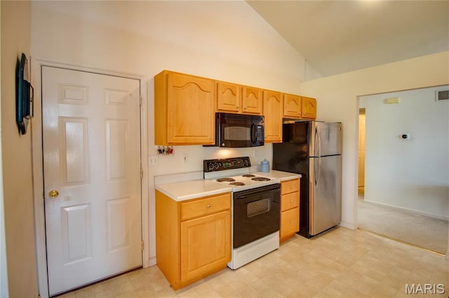 kitchen with black microwave, electric range oven, freestanding refrigerator, light flooring, and light countertops