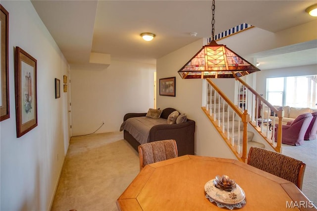 carpeted dining room with stairway