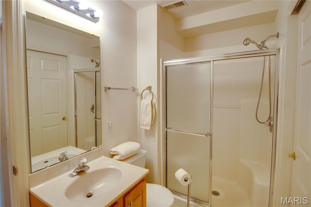 full bath featuring a shower stall, vanity, and toilet