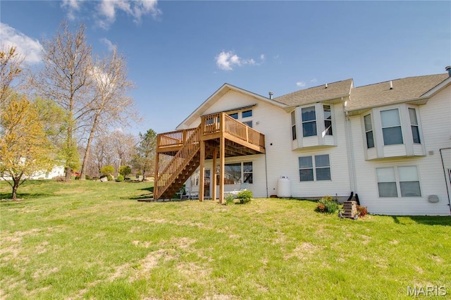 rear view of property featuring stairway, a wooden deck, and a lawn