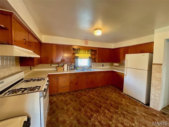 kitchen with white appliances, under cabinet range hood, open shelves, a sink, and dark floors