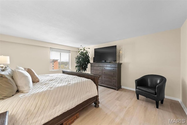 bedroom with light wood-style flooring and baseboards