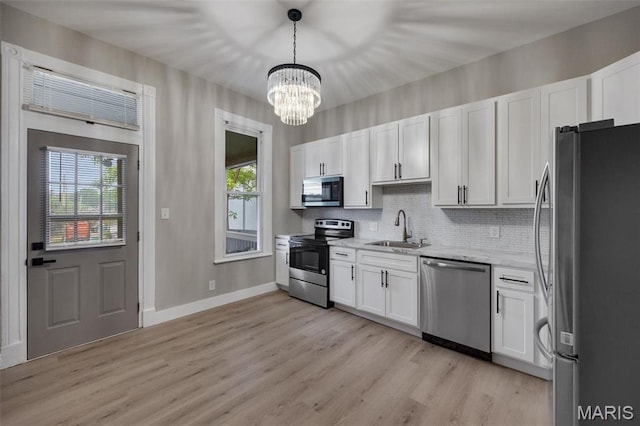 4311 Loughborough Ave, Saint Louis, MO 63116 - kitchen featuring appliances with stainless steel finishes, a chandelier, white cabinetry, and plenty of natural light