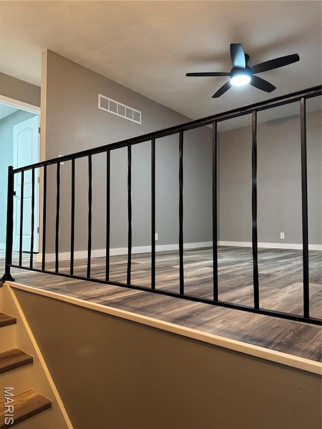 stairs featuring ceiling fan, wood finished floors, and baseboards